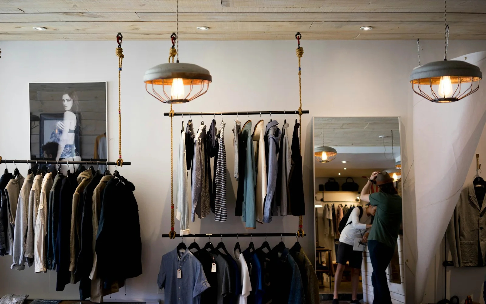 A neighborhood retail interior with clothing rails and warm pendant lights
