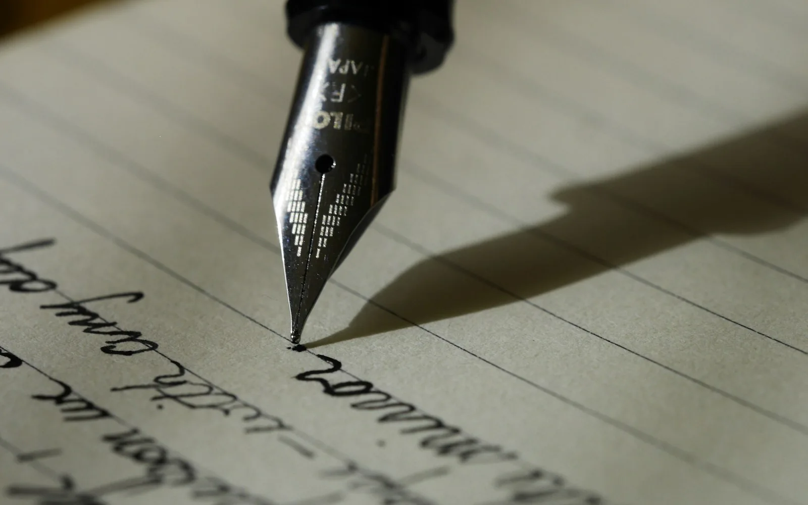 A fountain pen composing a handwritten page in warm light